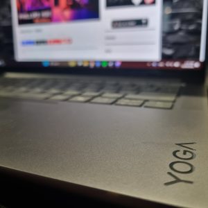 Lenovo Yoga Pro 7i Aura Edition Gen 10 sitting open, showing the "YOGA" on the internal base with The Empire NZ landing page open